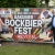 Vor dem Baustellenplakat Bakumer Bockbierfest Revival am 11. Juni 2022 stehen von links Gerd Beckmann, Doris Schumacher, Franz Hölscher und Clemens Berndmeyer